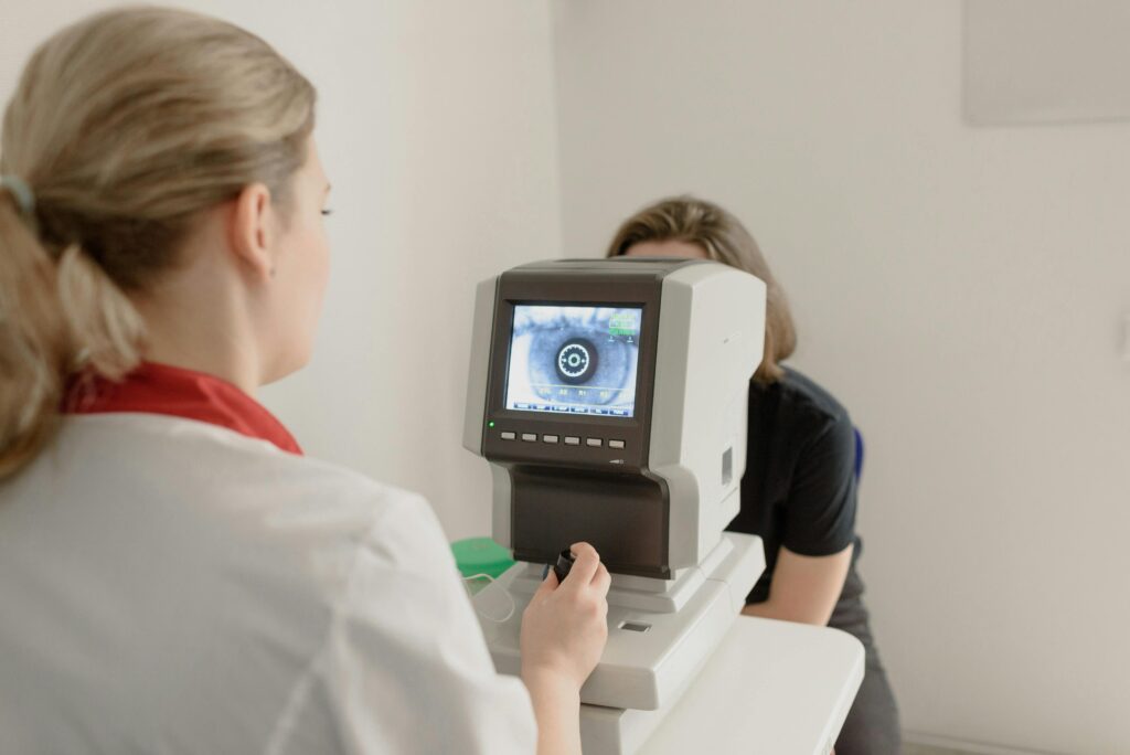 Eye technician performing digital eye scan using ophthalmology diagnostic equipment in a retina clinic supported by predictiveIT healthcare IT solutions.