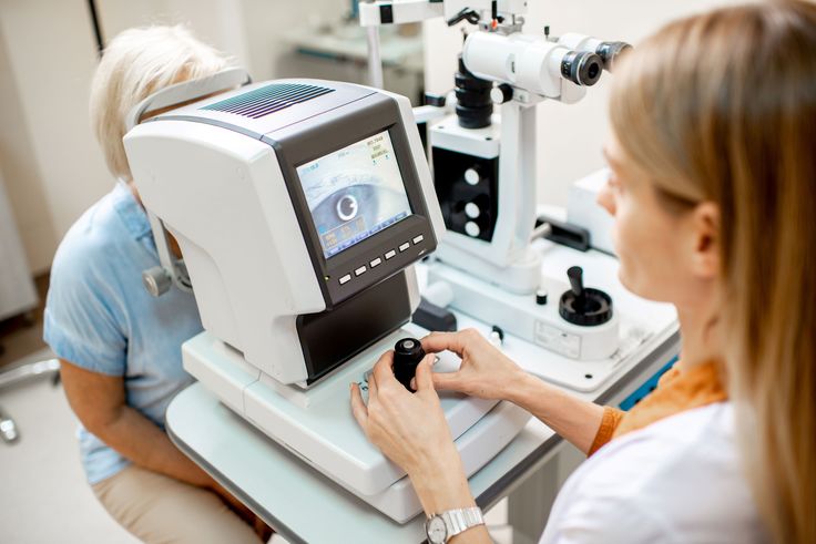 Eye doctor performing a digital eye exam using advanced ophthalmology diagnostic equipment in a clinic