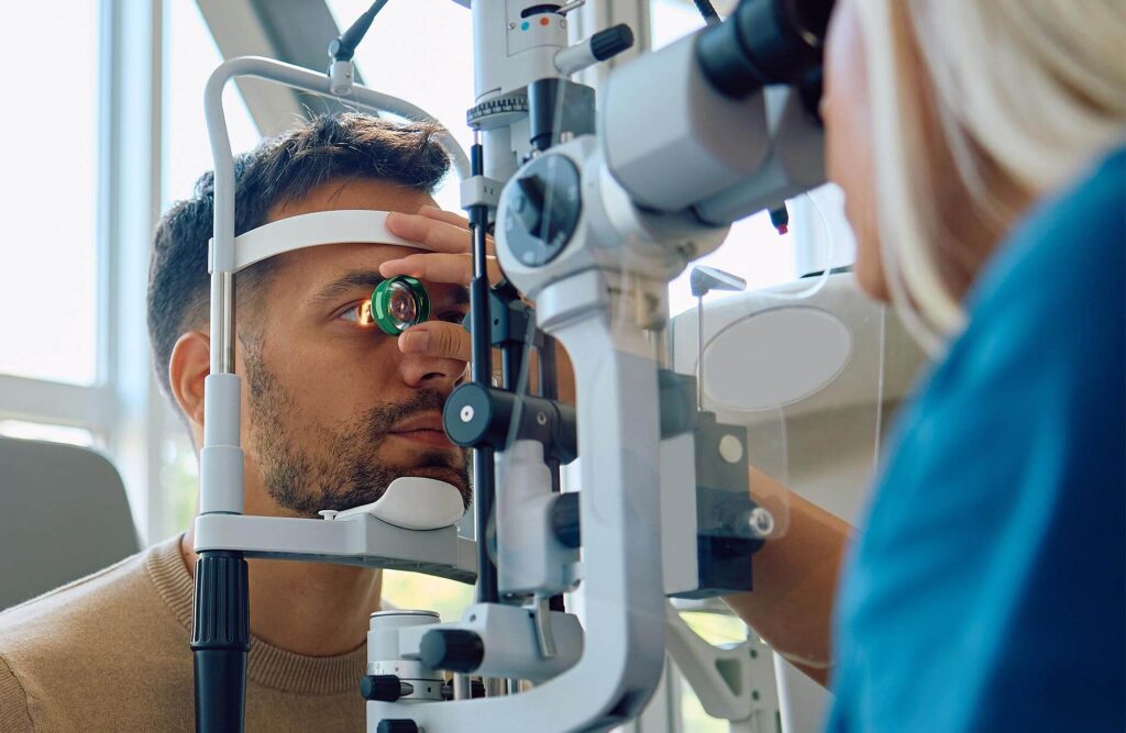 Male patient receiving a comprehensive eye exam with slit lamp equipment at an ophthalmology clinic