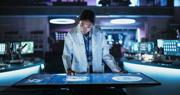 Scientist analyzing digital medical data on an interactive touchscreen display in a high-tech laboratory environment.
