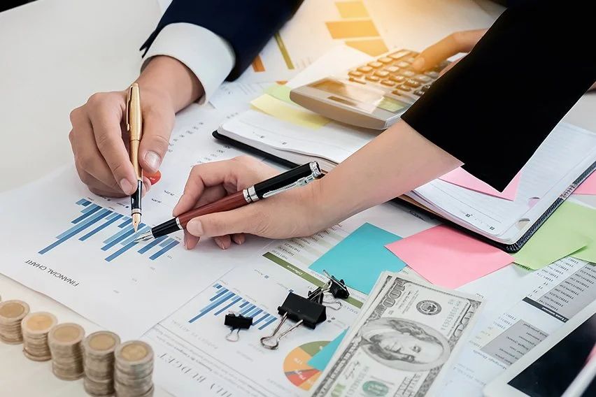 Financial advisors reviewing charts, reports, and financial documents during a technology and risk assessment.
