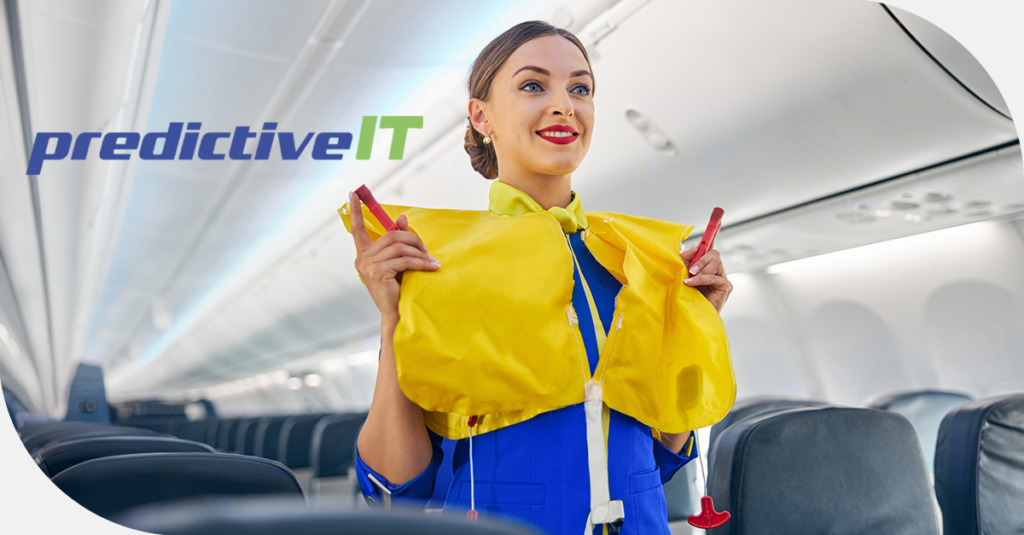 Flight attendant demonstrating how to put on a yellow life vest inside an airplane cabin, with the predictiveIT logo displayed in the upper left.