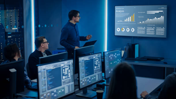 IT professionals monitoring systems and reviewing data analytics in a network operations center.